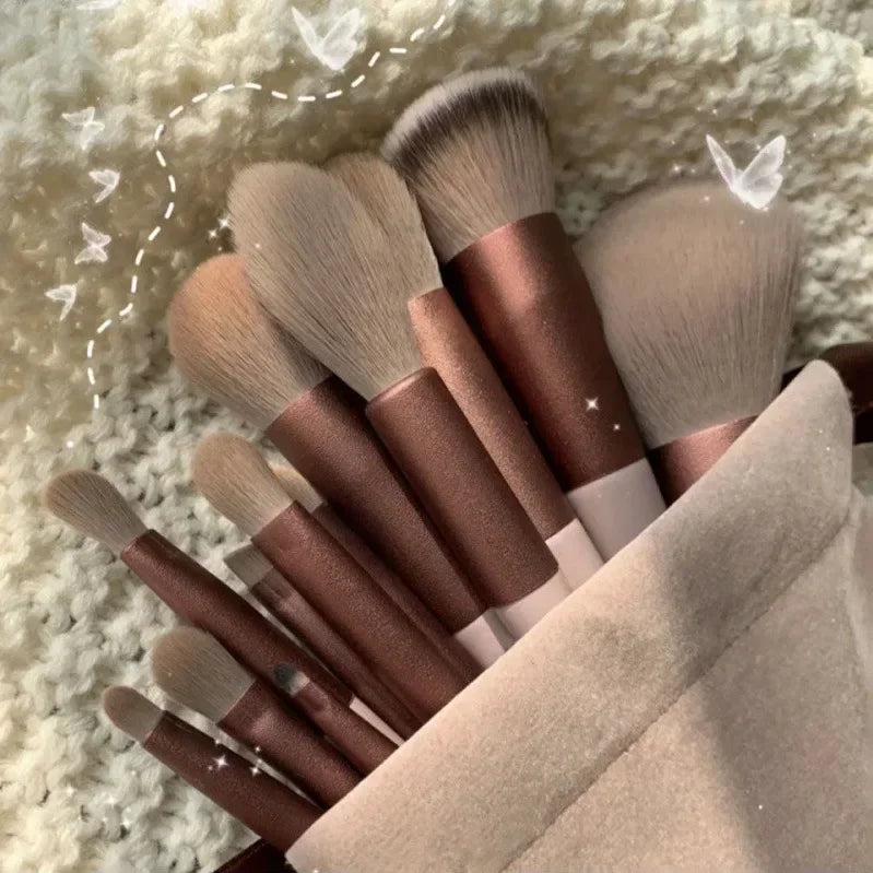 Set of makeup brushes with brown handles on a textured surface