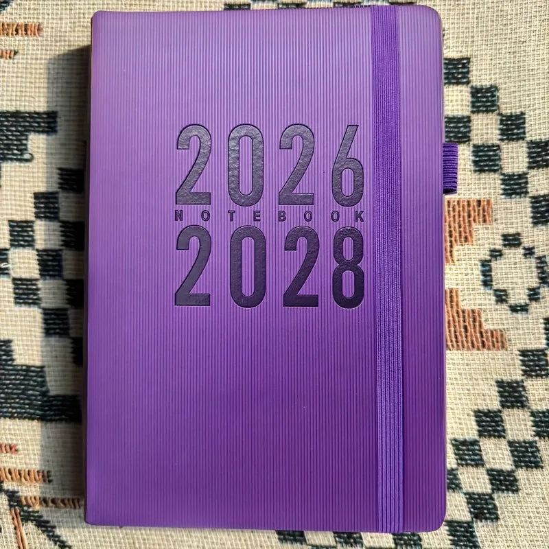 Purple notebook with '2026-2028' text on a patterned surface