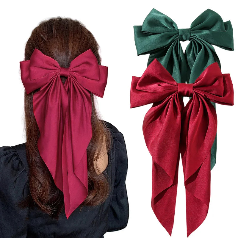 Red and green hair bows with a person wearing a red bow in their hair.