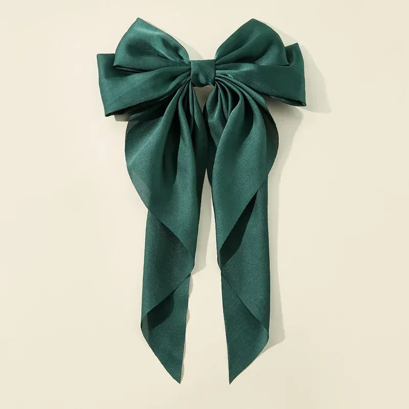 Green bow hair accessory on a beige background