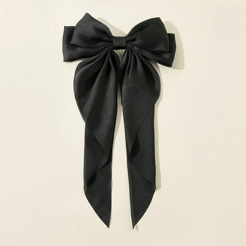 Black bow hair accessory on a beige background