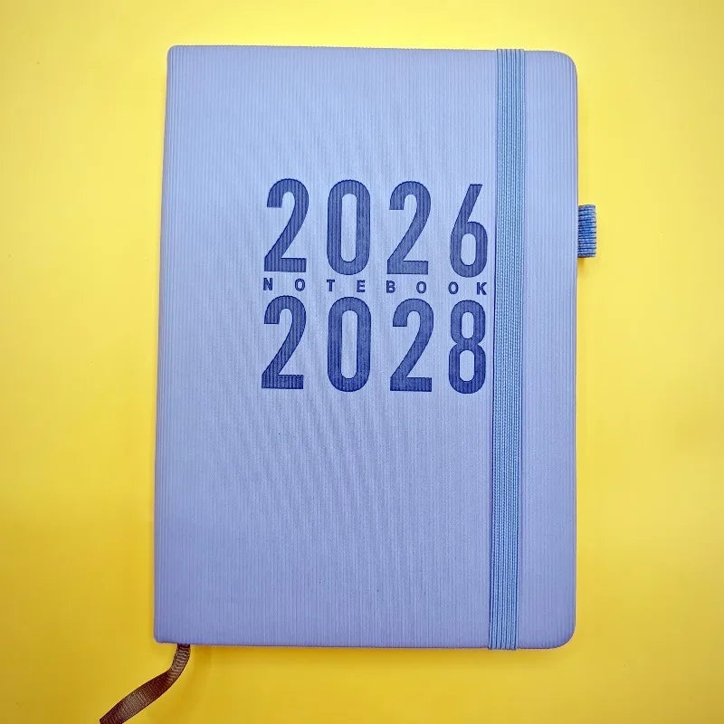 Blue notebook with '2026 Notebook 2028' text on a yellow background