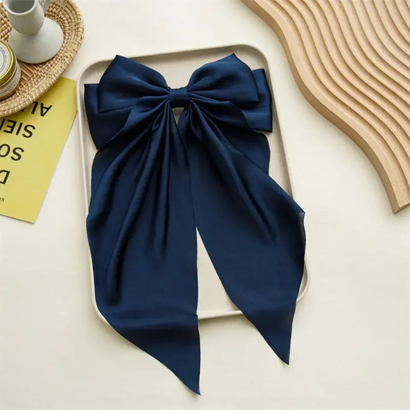 Blue bow-shaped scarf on a white tray with a neutral background