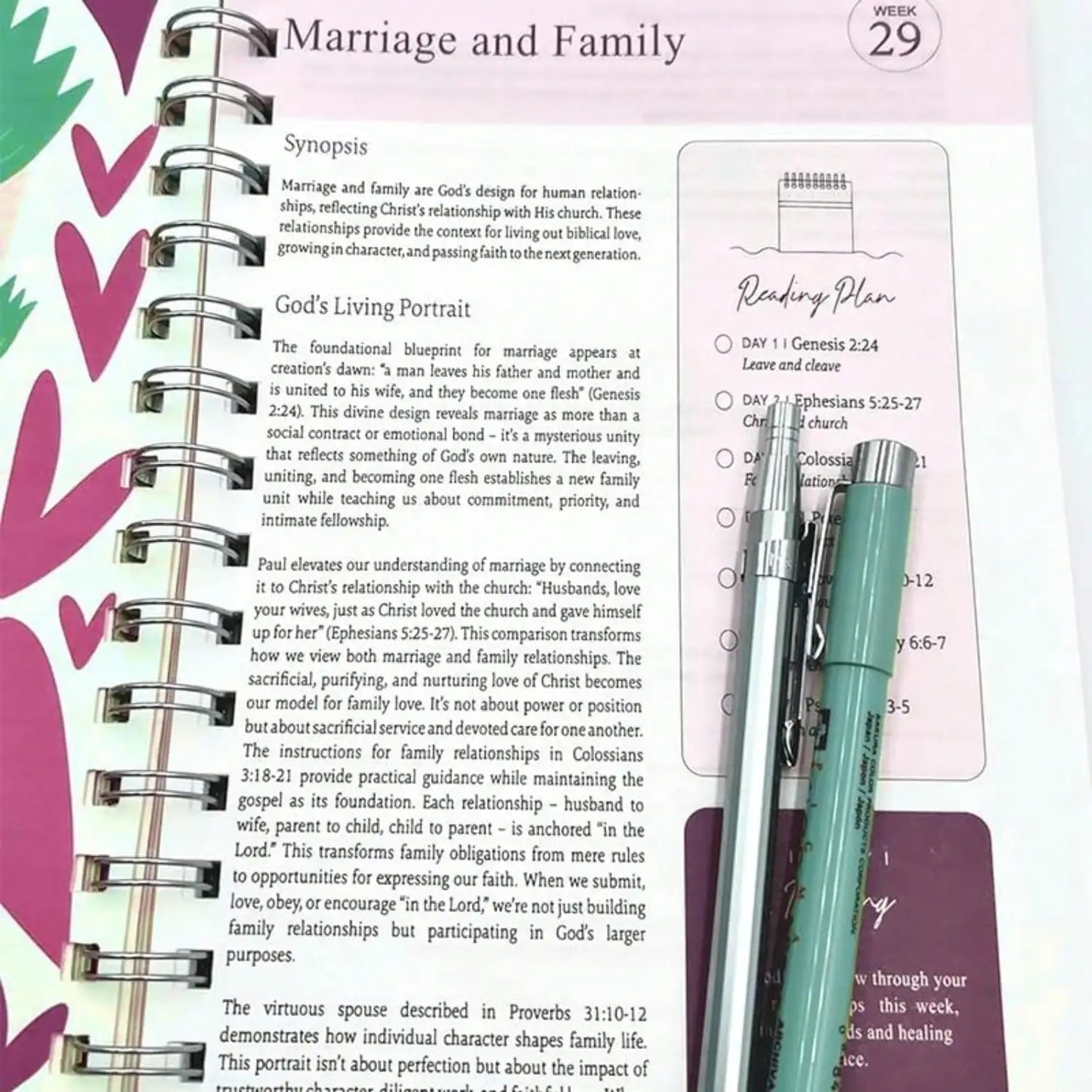 Open book with text on marriage and family, pens, and a colorful heart pattern.