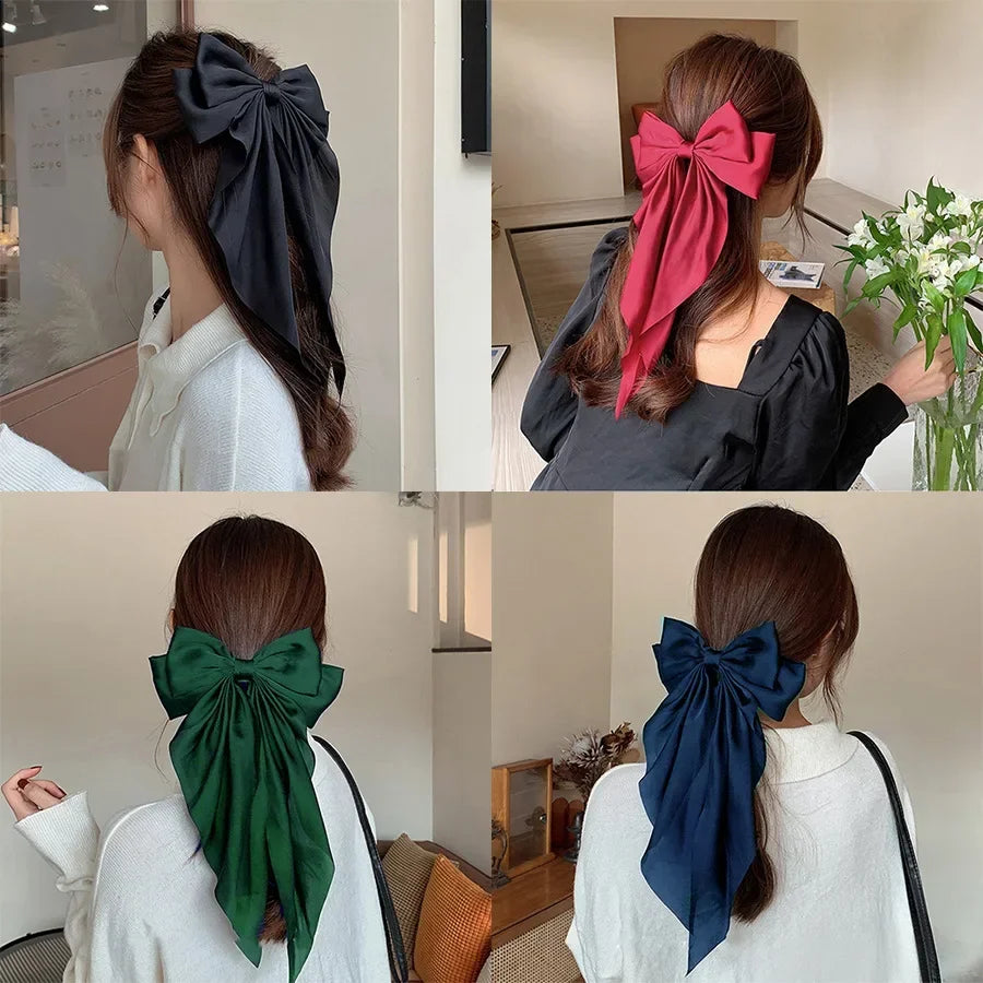 Four different colored hair bows worn by a person indoors.