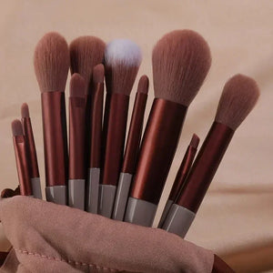 Set of makeup brushes with brown handles and bristles on a beige background