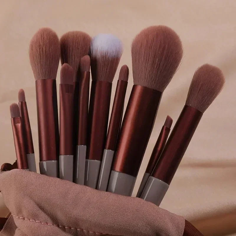 Set of makeup brushes with brown handles and bristles on a beige background